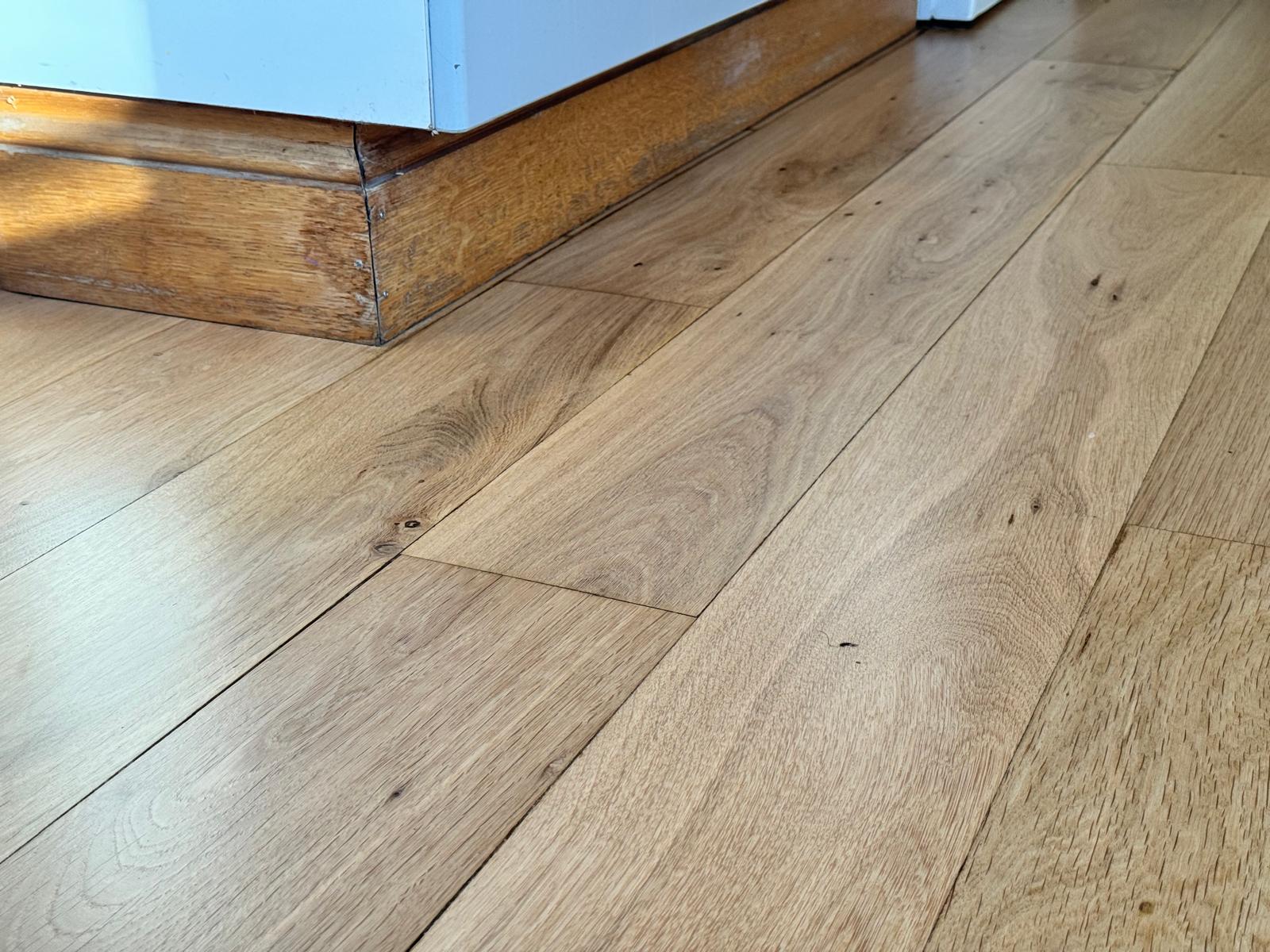 Stained and worn oak kitchen floorboards, before and after sanding and a natural finish, after