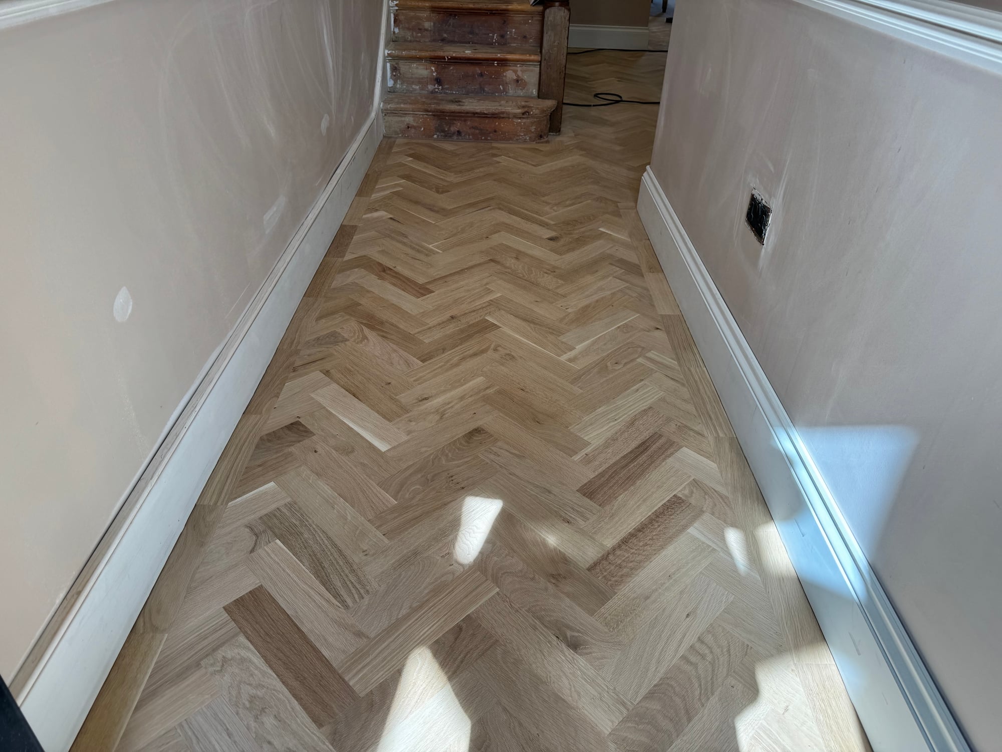 Refinished oak chevron parquet floor in a Putney hallway